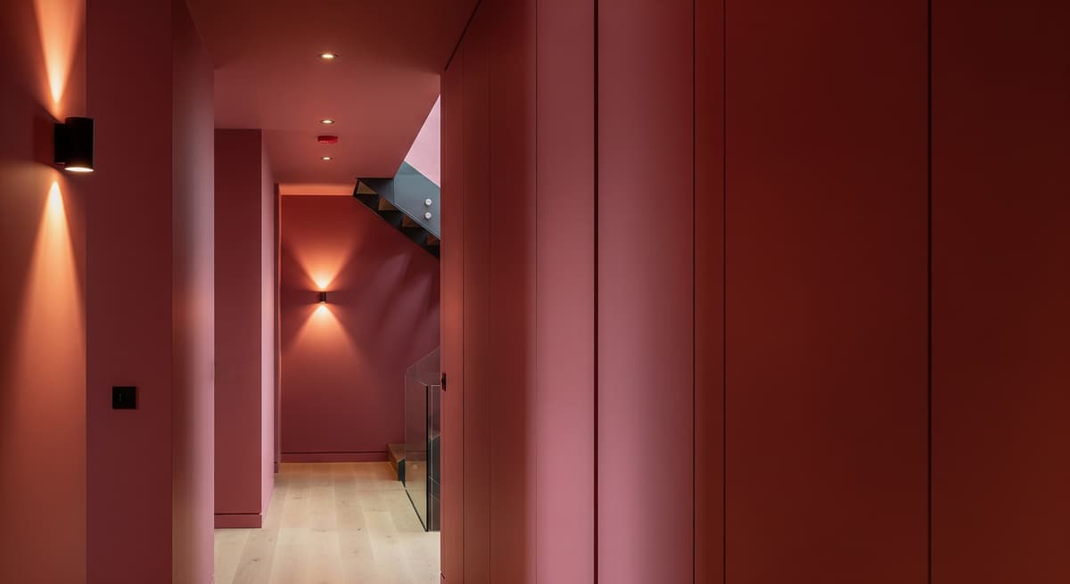 Deep red interior with carefully aligned joinery and warm architectural lighting
